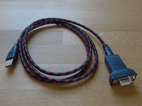 USB to DB9F serial adapter on a wooden surface.